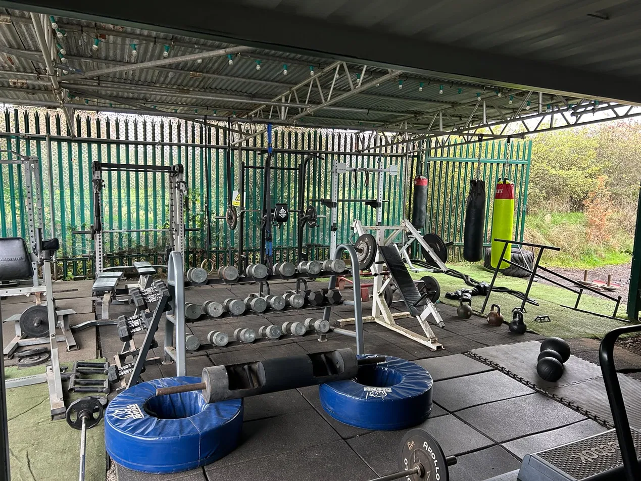 view of a log lift bar, freeweights, cycling machine and pull up bars